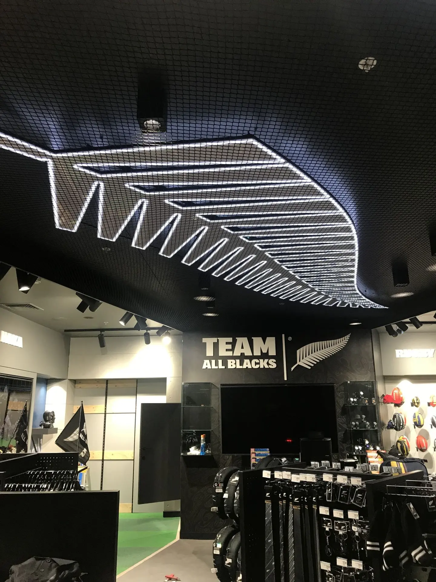 Illuminated ceiling lighting and wall signage for the Team All Black experience.