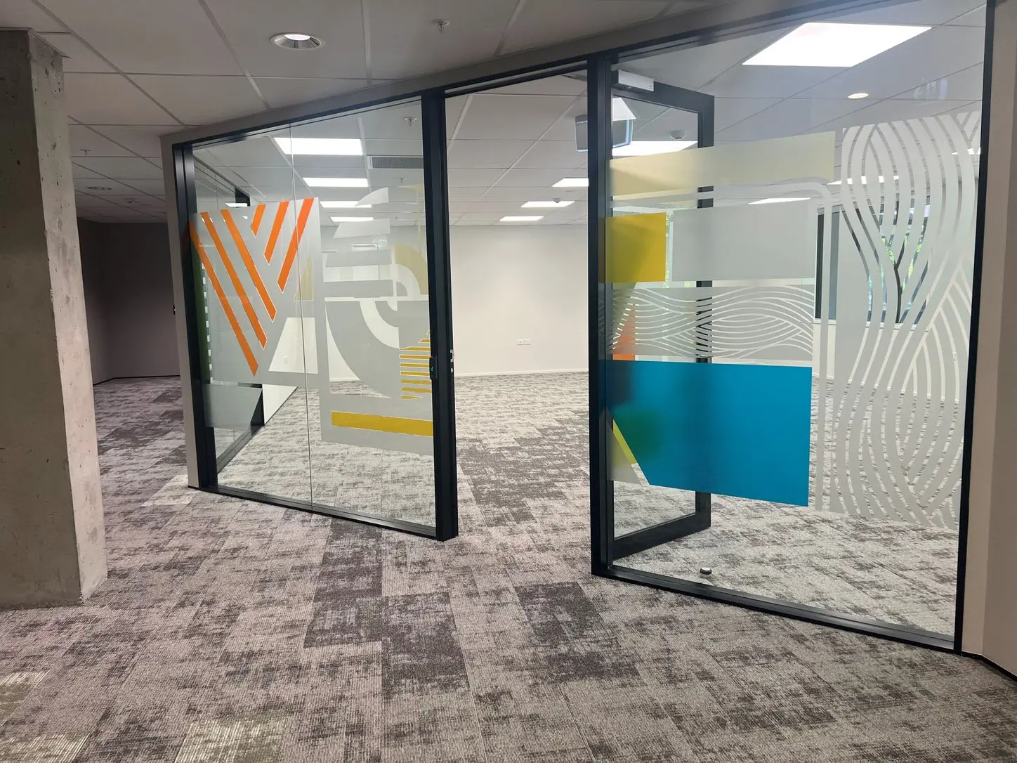 This modern office space features bold, eclectic window graphics across meetings rooms and hallways.