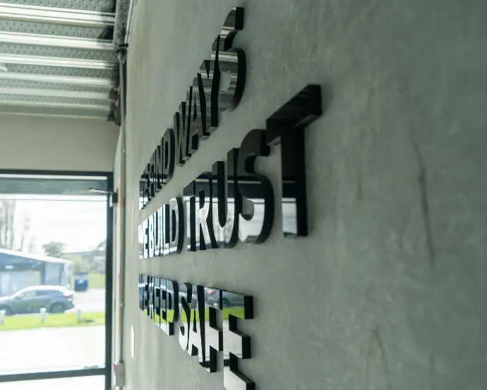 Custom acrylic cut lettering on a interior wall for Supertyre, showcasing their customer commitments