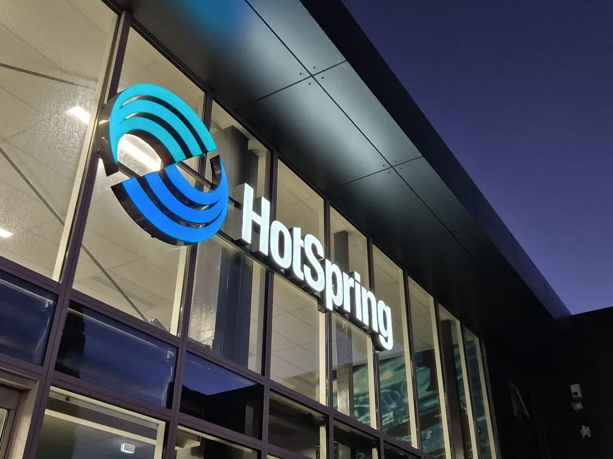 Illuminated logo icon and 3D branding on building exterior for Hot Spring Spas in Hornby. 