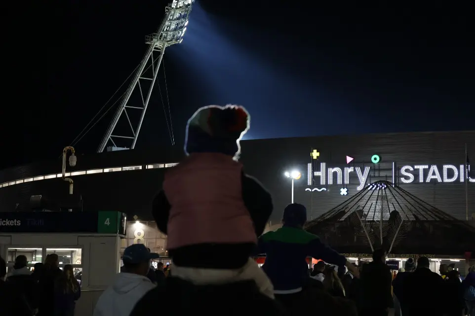 Image shows a child on shoulders heading into the HNRY Stadium in Wellington. The new illuminated HNRY logo is in the background, fabricated and installed by Displayworks.