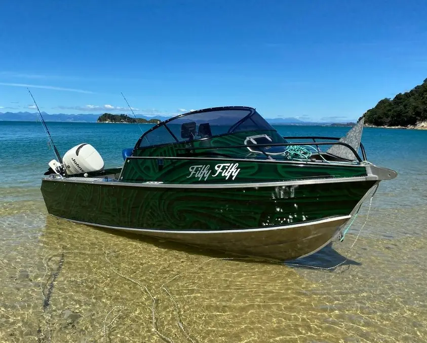 Custom boat wrap and boat name graphics on a family fishing boat in the Abel Tasman